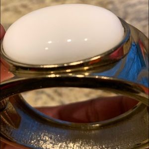 Gold colored bangle with white stone